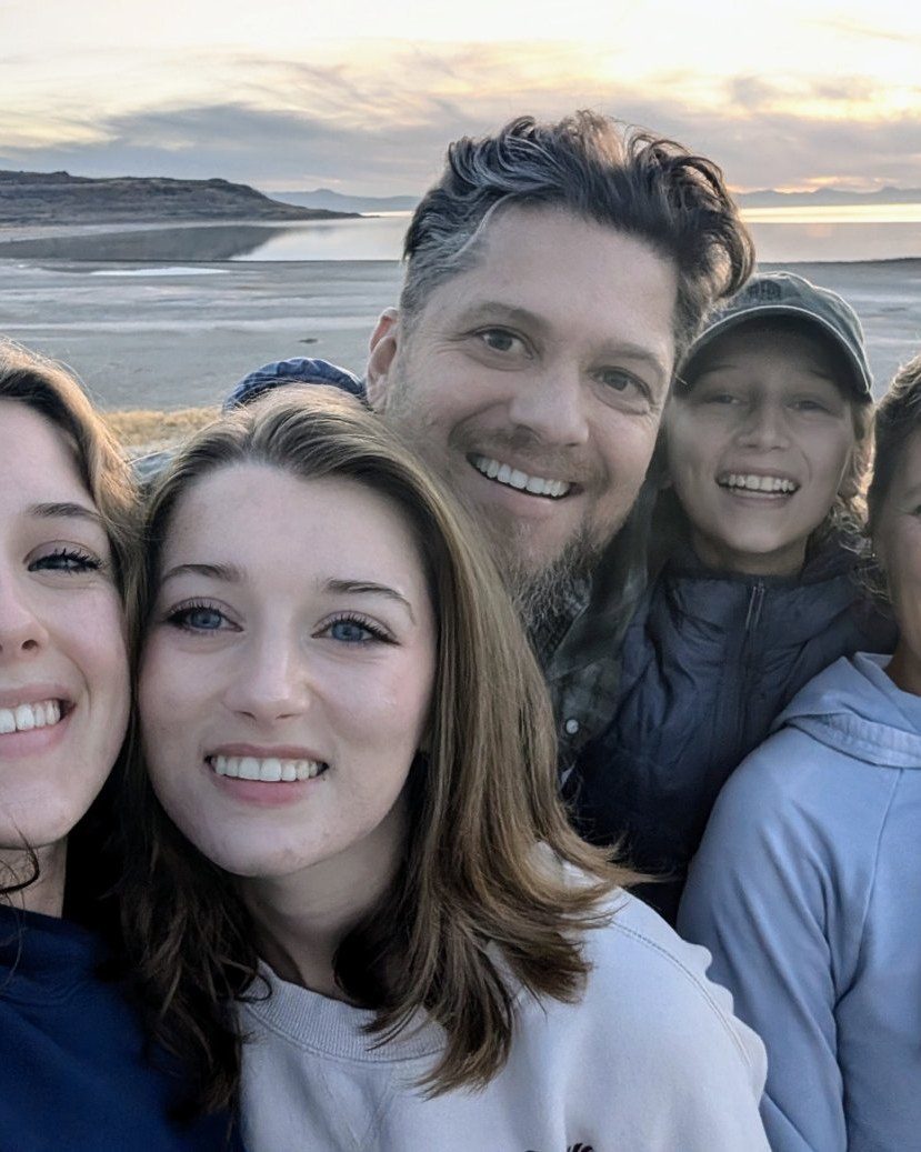 Ben Page with his family at the shore at sunset.